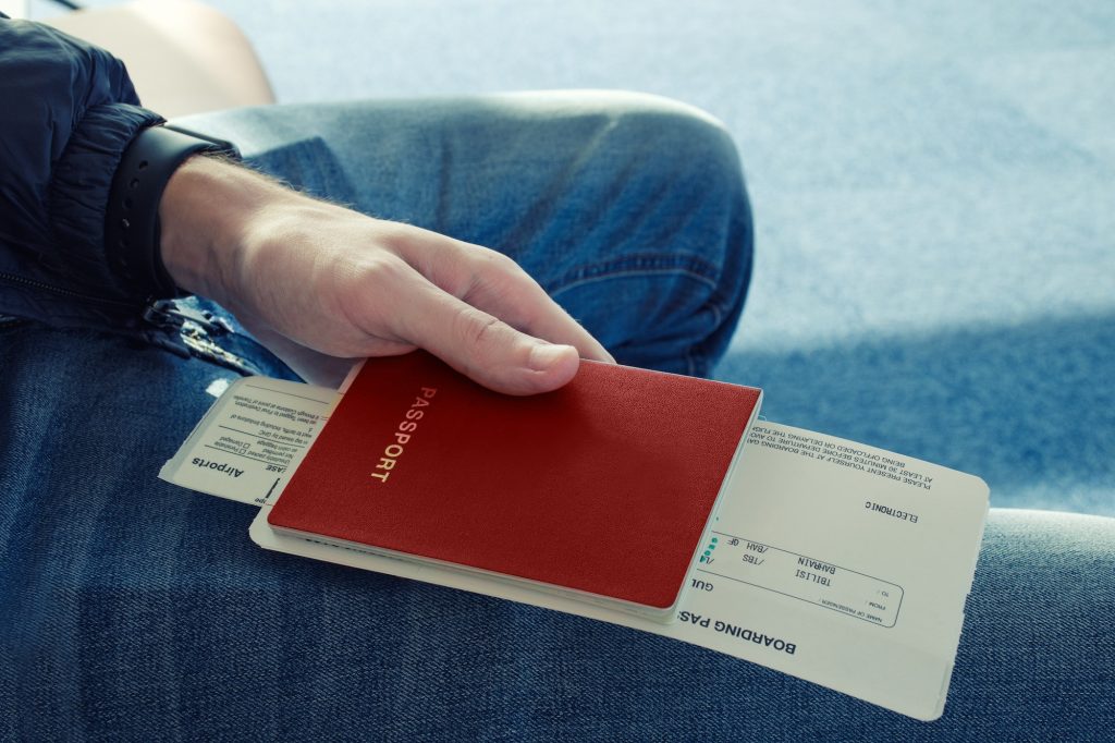 A man holds passport with tickets to the plane