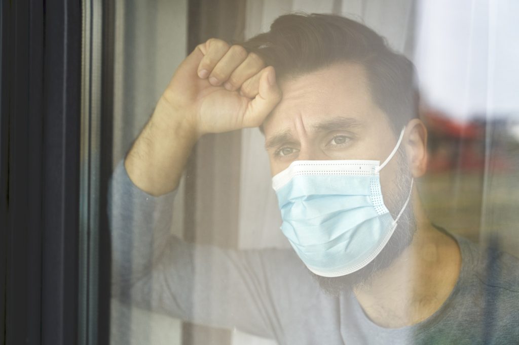 Close up of man on quarantine looking through the window