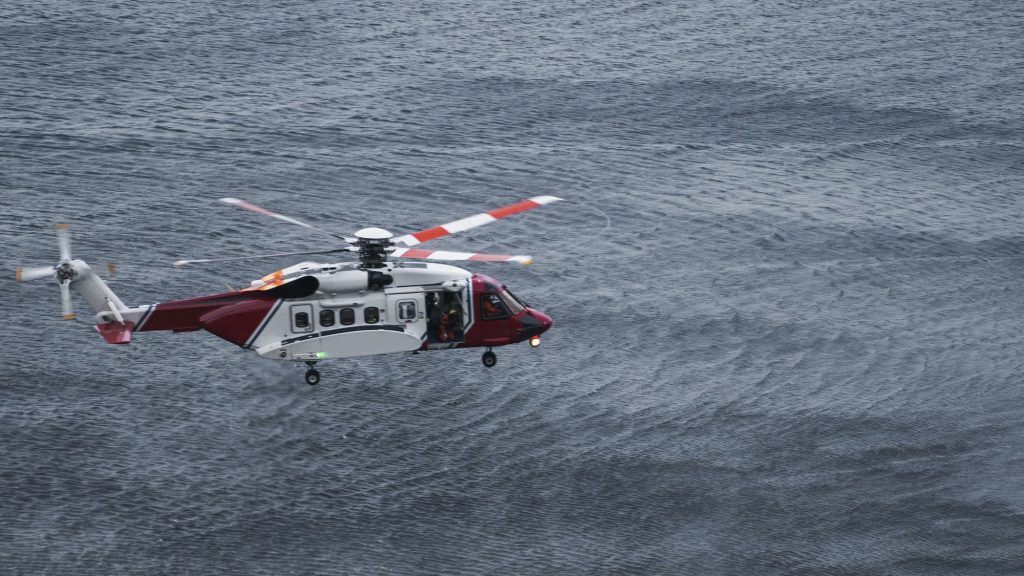 Coastguard helicopter flying over the sea in Scotland