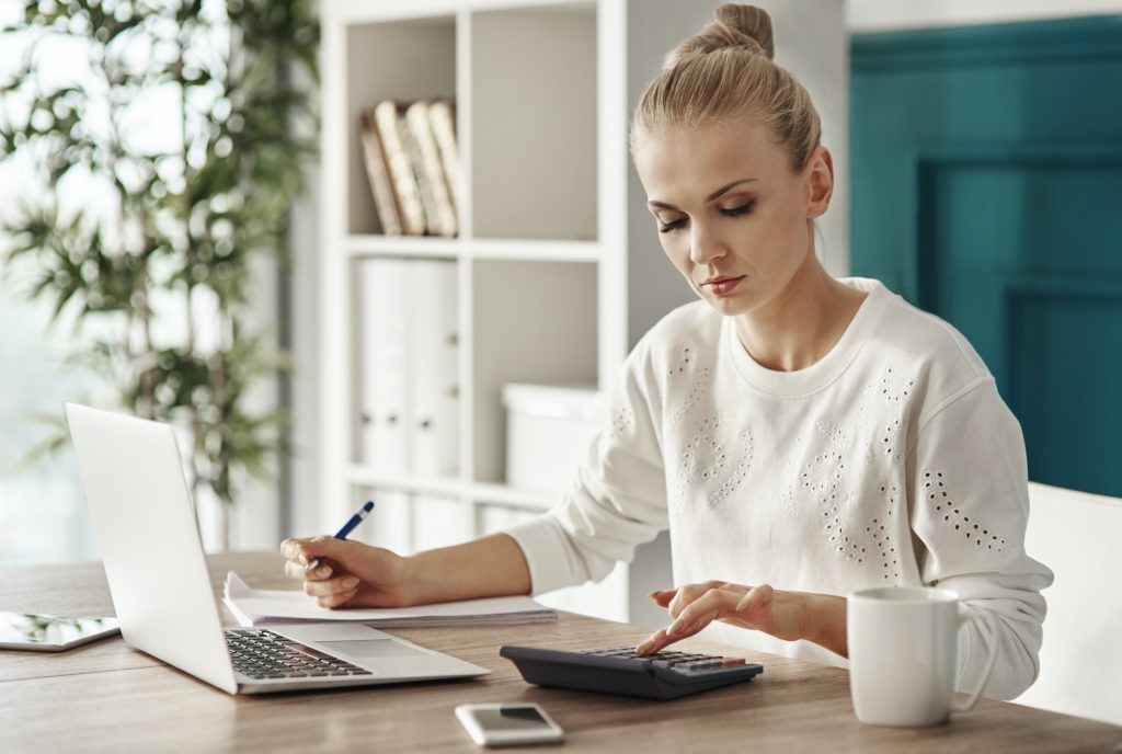 Concentrated woman budgeting at office