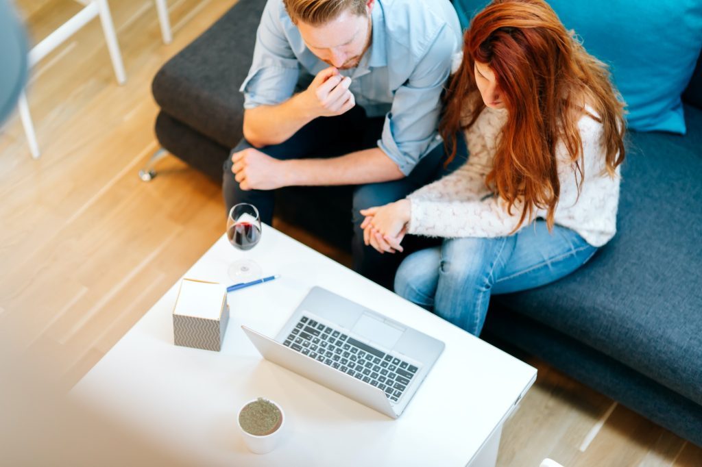 Couple browsing web together in living room