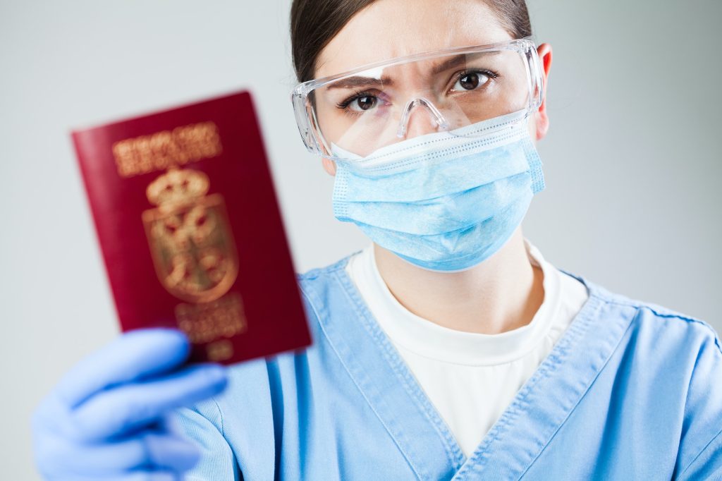 Doctor or nurse at airport customs security check holding a passport
