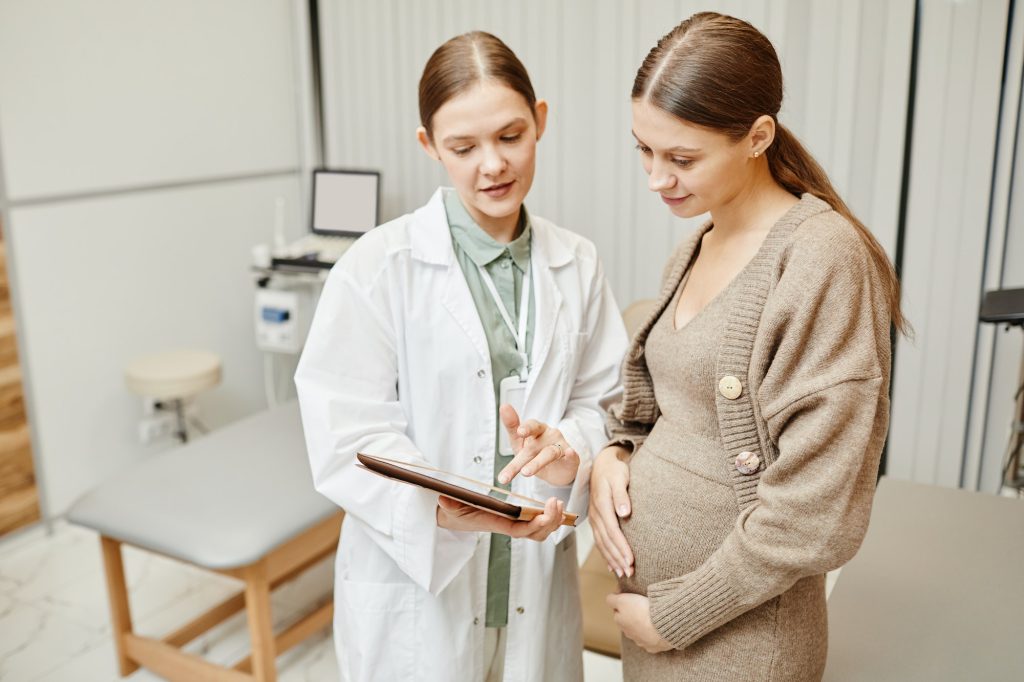 Doctor Talking to Pregnant Woman in Clinic