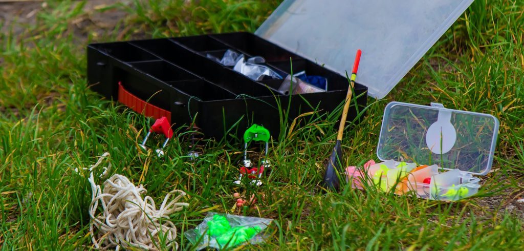 Fishing rod and accessories for fishing on the grass. Selective focus.