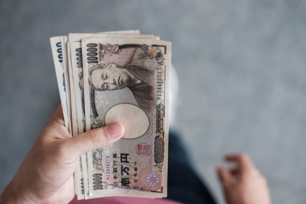 Hand holding Japanese Yen banknote