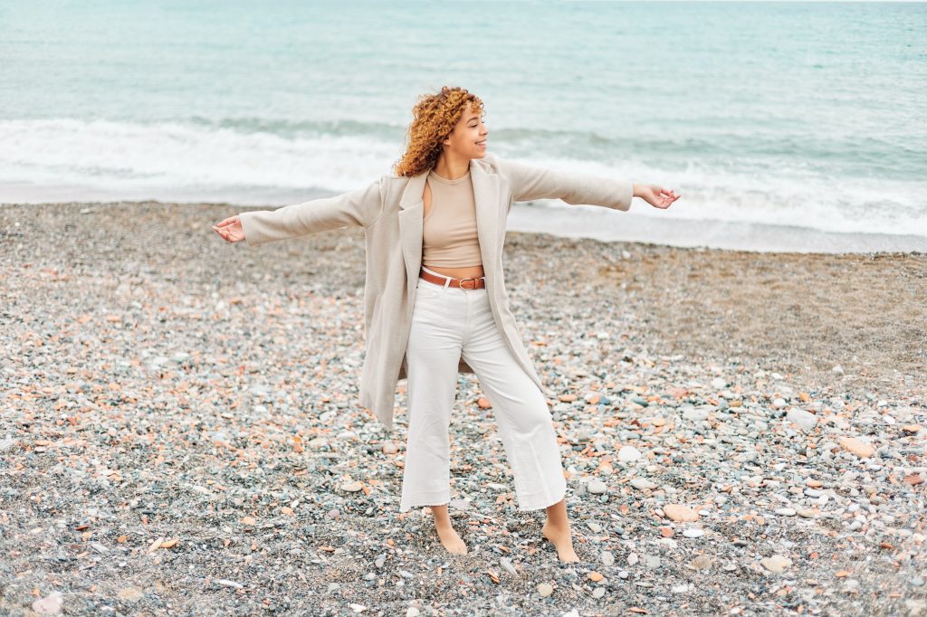 Happy curly woman on the beach