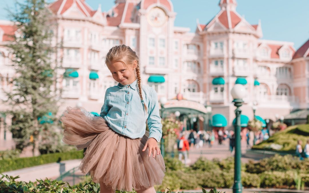 Little adorable girl in Cinderella dress at fairy-tale Disneyland park