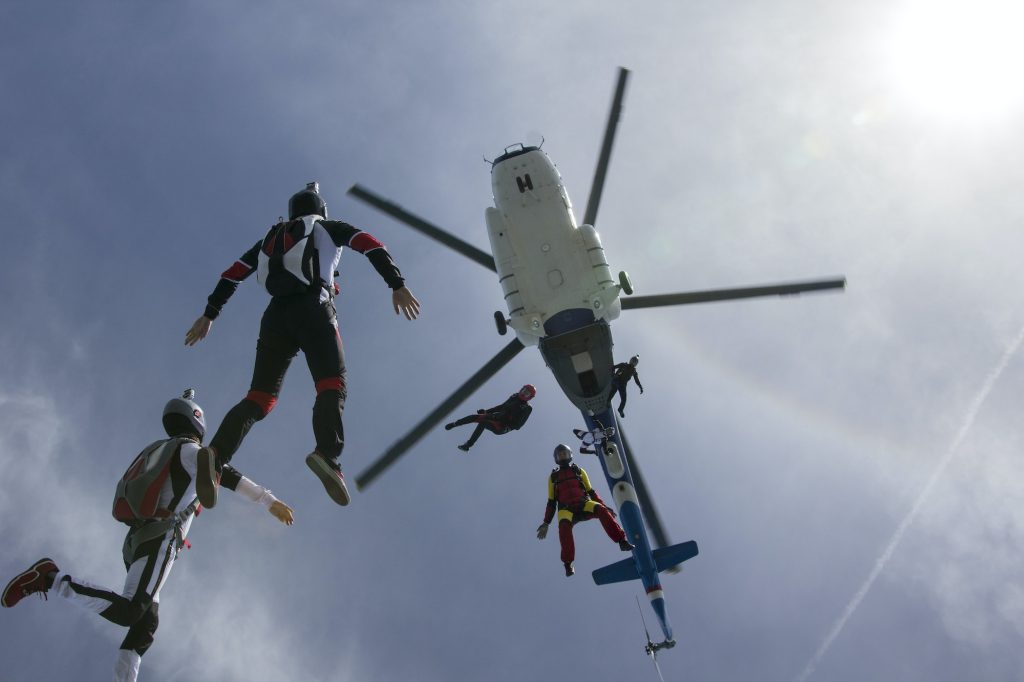 Low angle view of helicopter and six skydivers free falling, Siofok, Somogy, Hungary