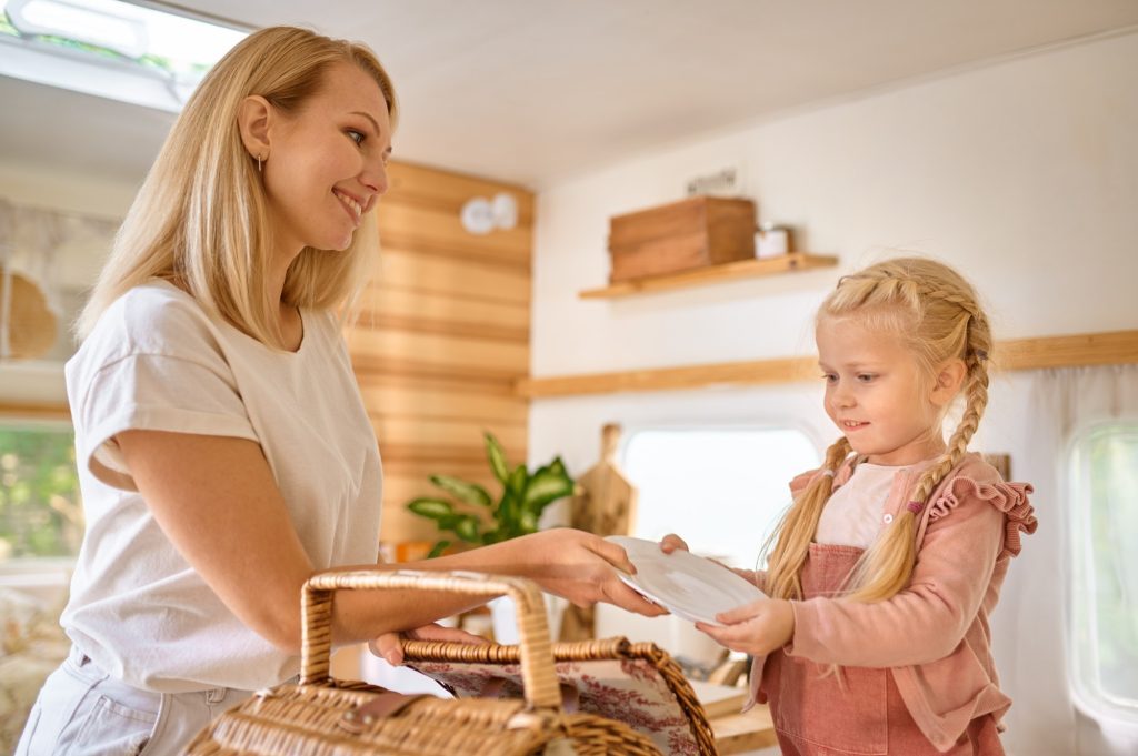 Mother and daughter on kitchen in trailer, camping