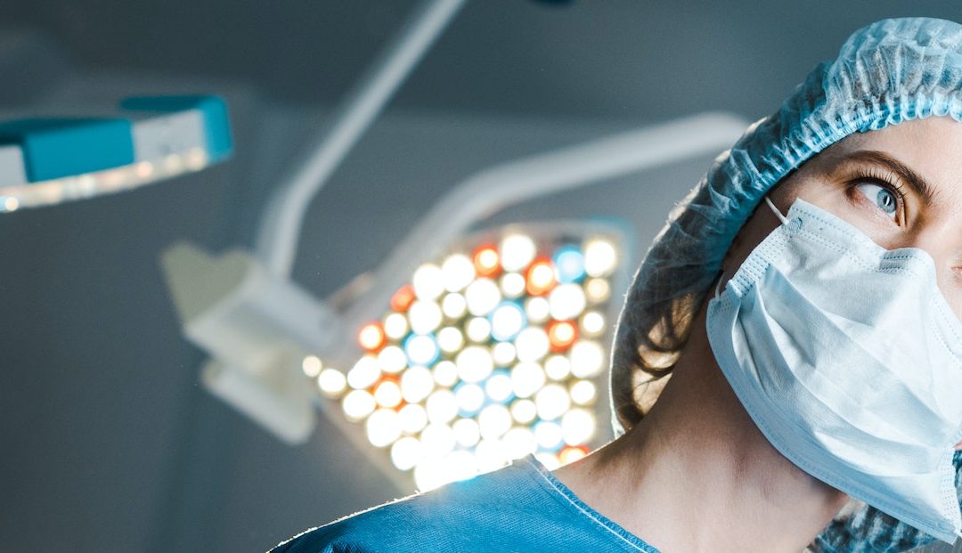 panoramic shot of nurse putting off medical mask in operating room