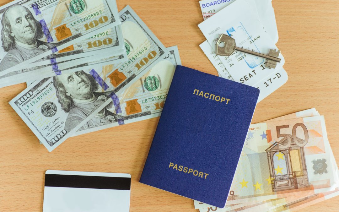 passport, dollars, key, and bank card on a wooden background.