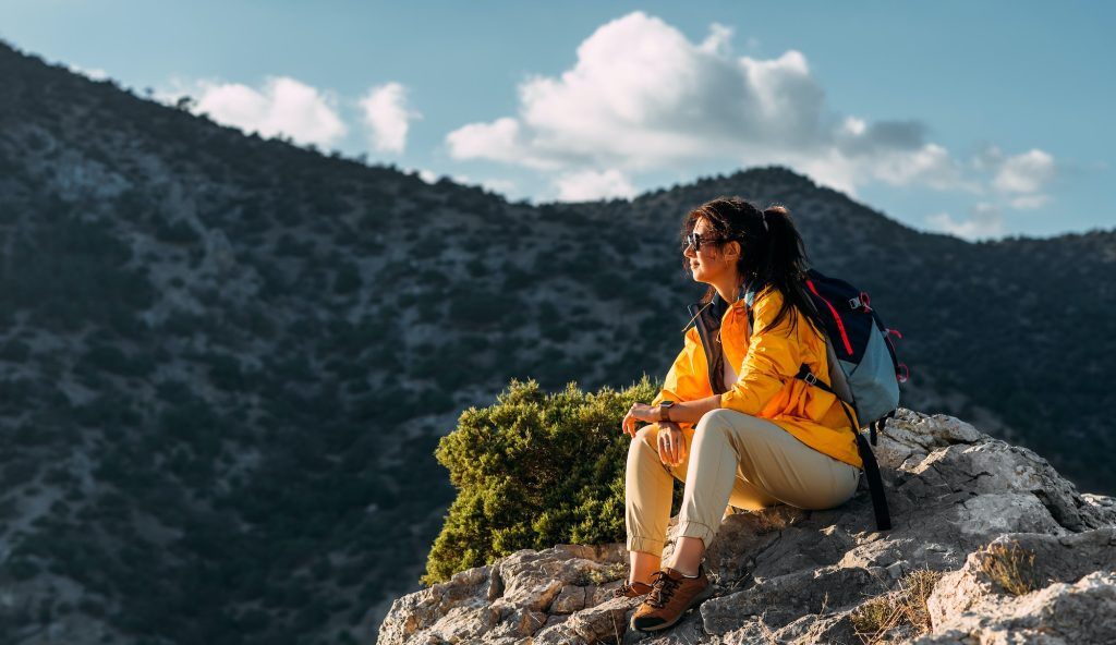Portrait of a female traveler in the mountains. Adventure, travel and hiking concept
