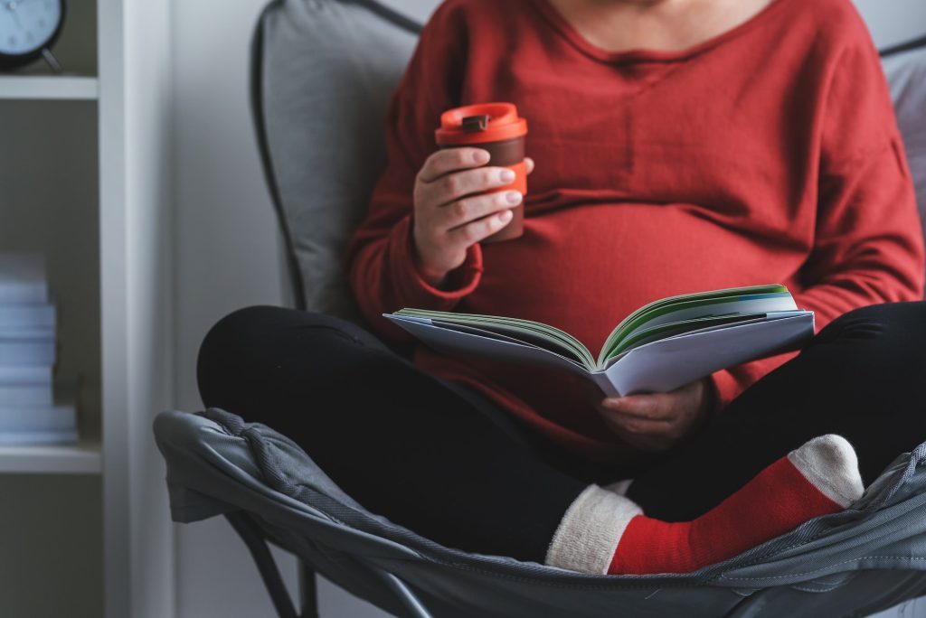 pregnant-woman-reading-book-in-living-room-1024x684-9840984