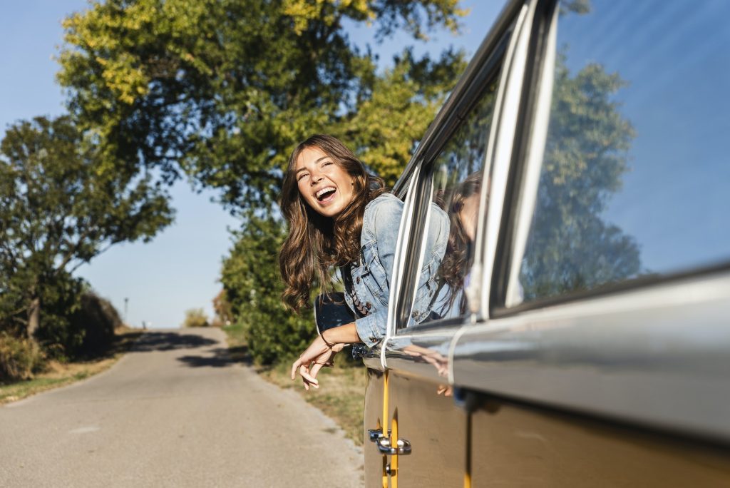 Pretty woman on a road trip with her camper, looking out of car window