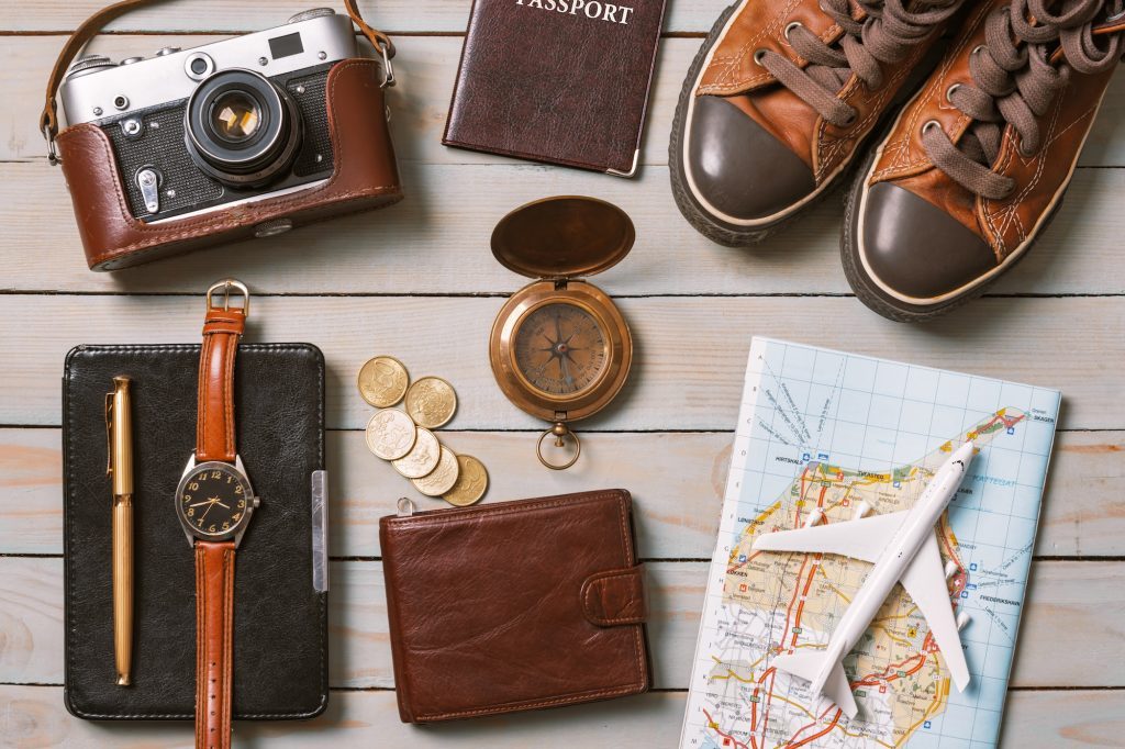 Set of traveler essentials on wooden background