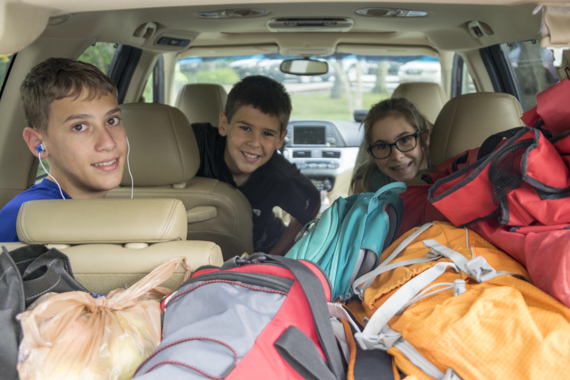 Siblings packed into the family car for a road trip