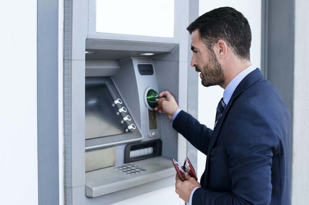 side-view-of-businessman-using-atm-at-subway-station-1024x680-6698678