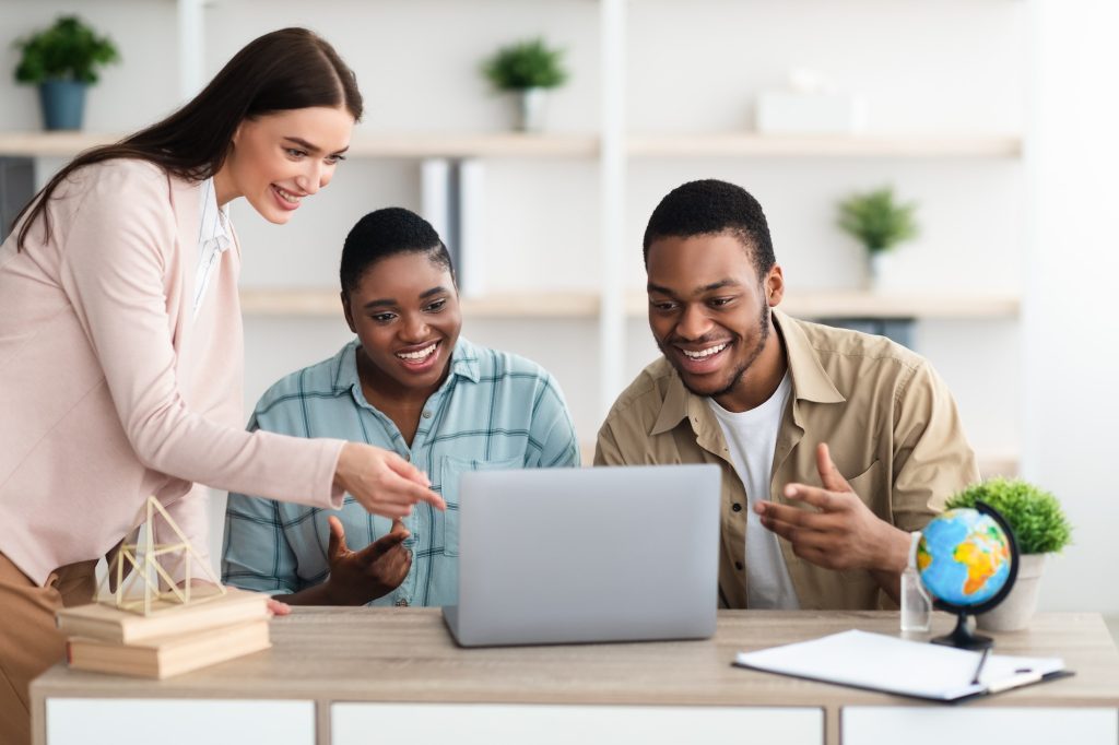 Travel Agent Offering Vacation Tour For African Couple In Office