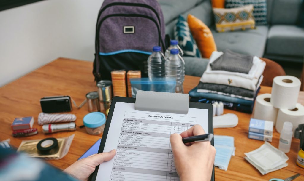 Woman doing checklist of emergency backpack