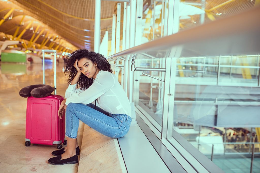 Woman sad and unhappy at the airport with flight canceled