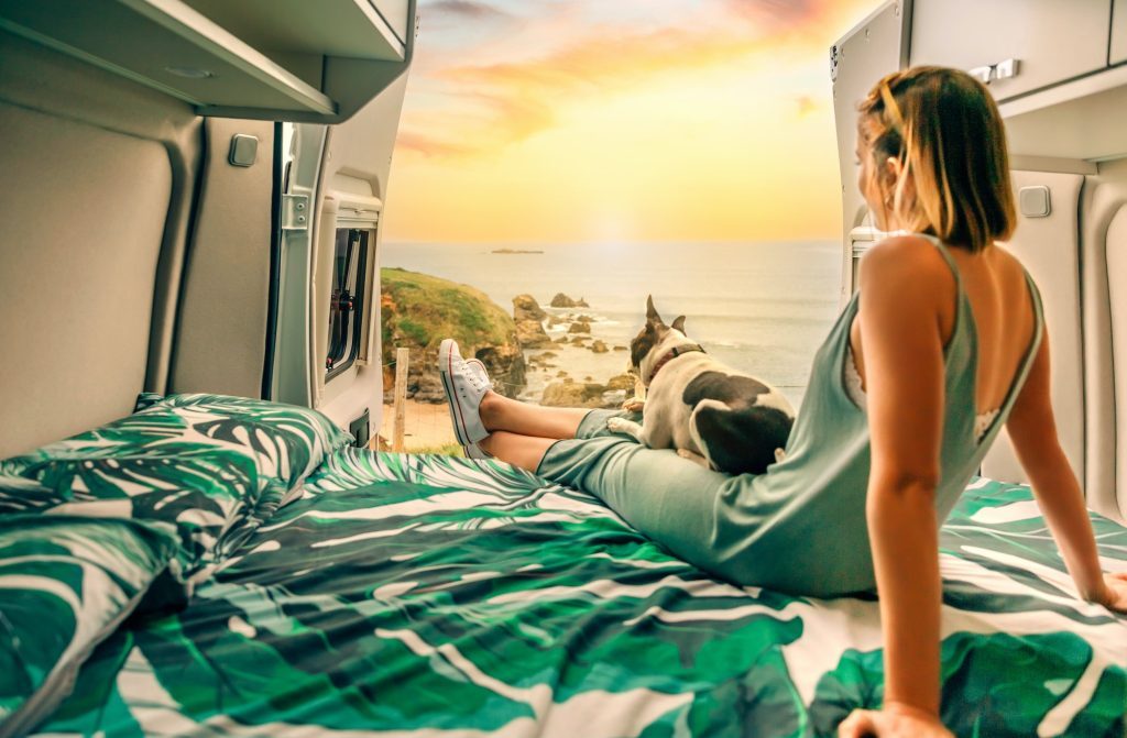 woman-with-her-dog-watching-the-sunset-sitting-on-the-bed-of-her-camper-van-1024x671-5968388