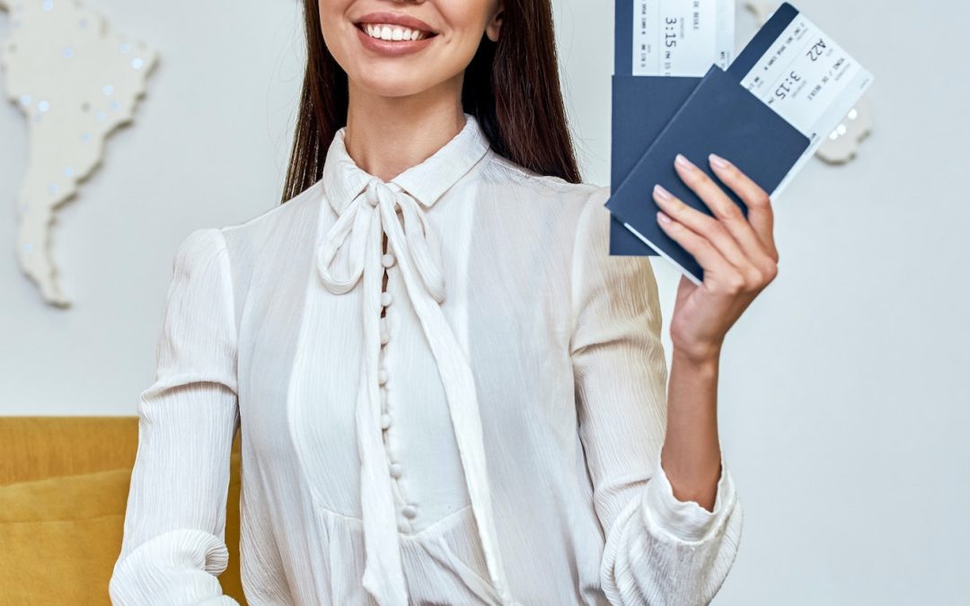 Young woman travel agent with flight tickets in hands